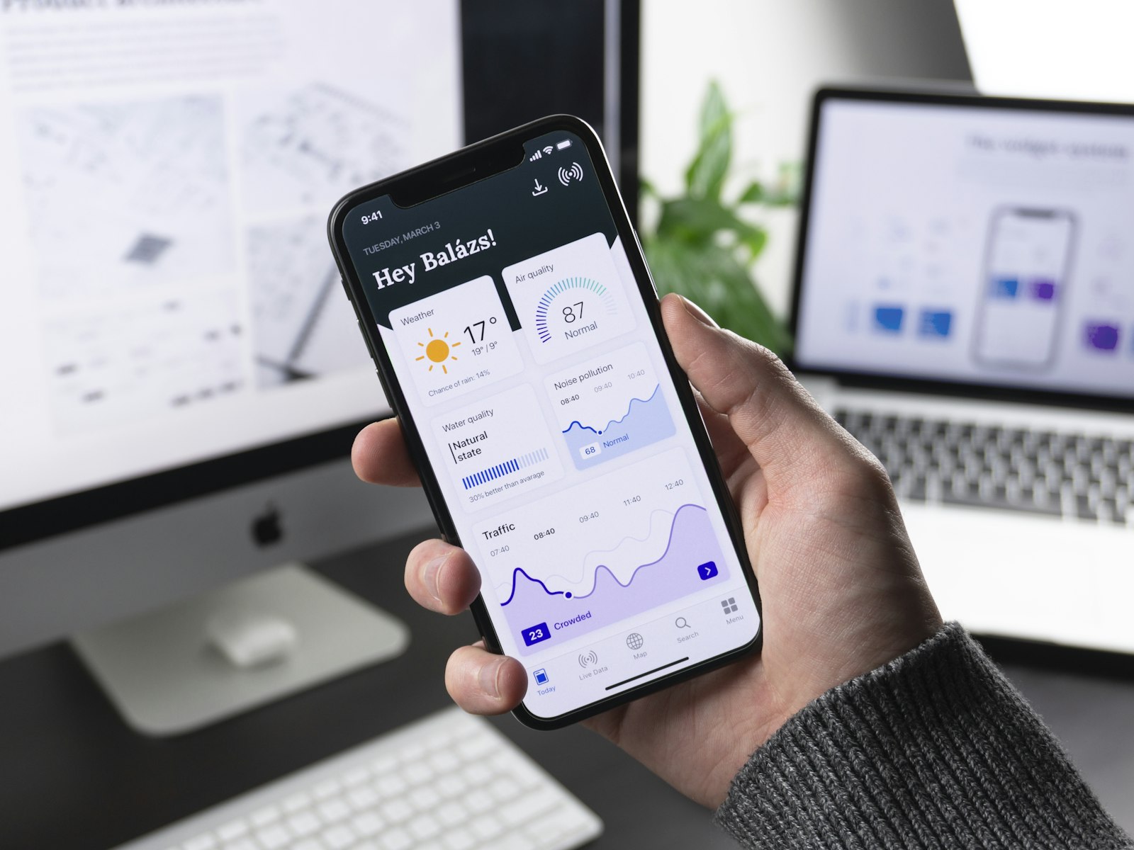Hand holding a smartphone running a modern dashboard app
